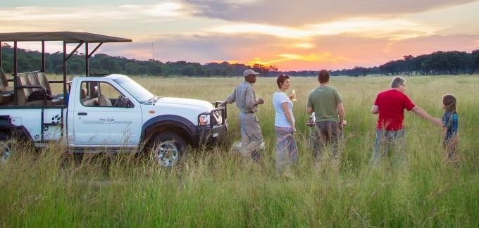 Botswana Familienreise - Botswana for family individuell - Jeep und Menschen vor Sonnenuntergang