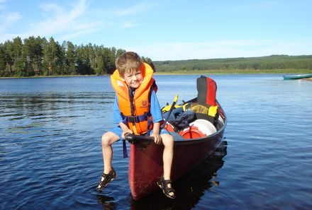 Schweden mit Kindern - Schweden for family - Kind sitzt auf Kanu