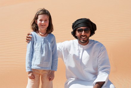 Erfahrung im Oman mit Kindern - Oman Rundreise mit Kindern - Erfahrungen in Oman mit Kindern - Einheimischer mit Kind in der Wüste