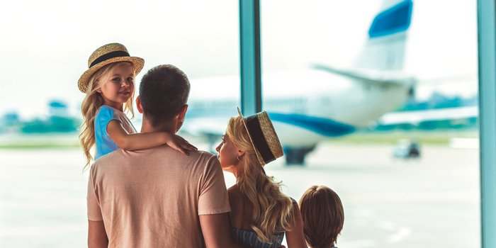 Die besten Reiseziele für Familien - Unsere beliebtesten Familienreisen 2018 in Europa & weltweit - Eltern mit zwei Kindern am Flughafen