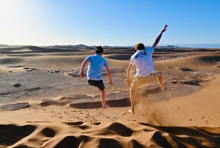 Marokko mit Kindern - Marokko for family - Kinder springen auf den Dünen in der Wüste